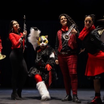 La Banda La Inquieta tocando en la Plaza de Armas: trombones, trompeta y bombo, de rojo y negro.