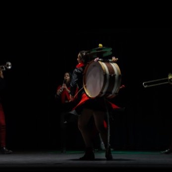 El bombo y los trombones de la banda, sobre un fondo oscuro.