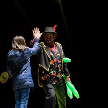 El payaso y la persona del público, juntos en la pista con las clavas.