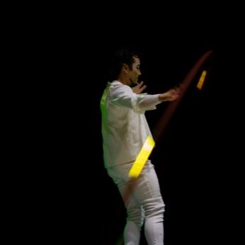 Un artista de blanco con un aro grande sobre el escenario.