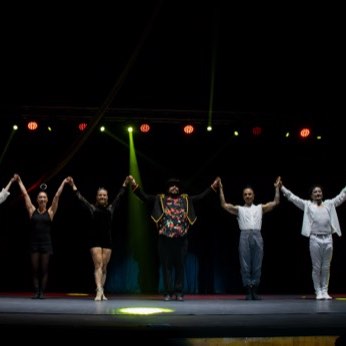 Todo el elenco tomado de la mano, saludando con los brazos en alto al final de la función.