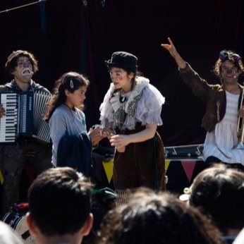 Los tres artistas en fila, tocando para el patio entero.
