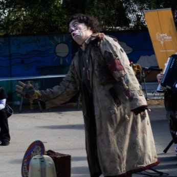 Un artista se aleja por el patio al terminar su número.