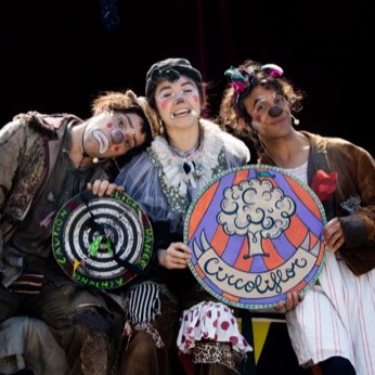 Los tres artistas rodeados de niños, posando para la foto.