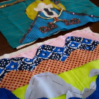 Dos arpilleras terminadas, una de fondo turquesa con una figura y otra de franjas de colores.